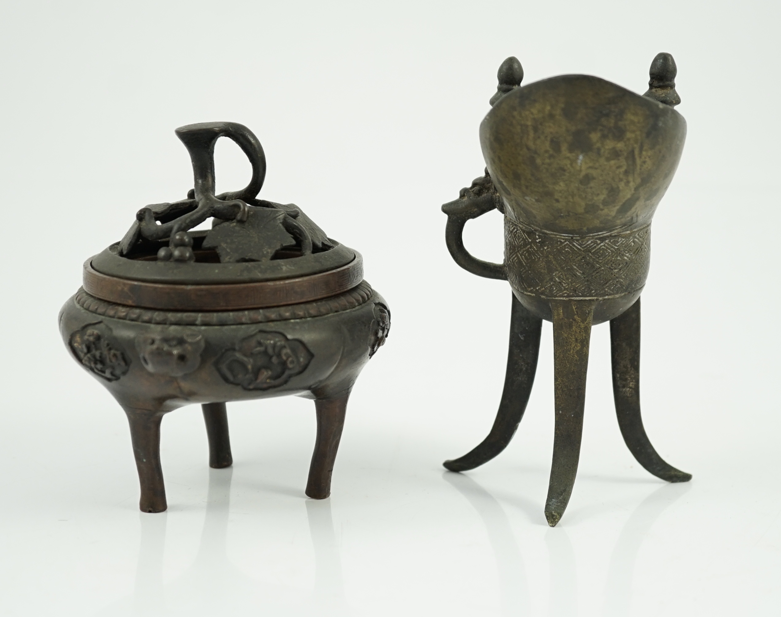 A Chinese bronze and copper alloy tripod censer and cover and a Chinese archaistic bronze tripod vessel, yi, both 17th century